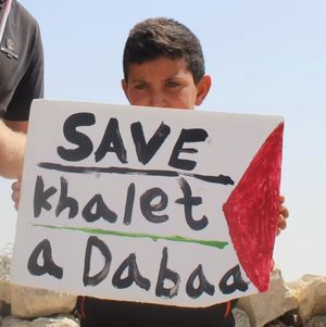 Child holding a sign that read `Save Khalet aDabaa`